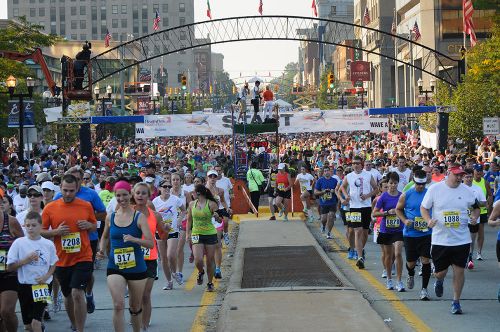 The image is of a running marathon. There are crowds of people running in the street.