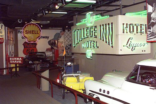 The image is of antique cars, college inn hotel signs, and more memorabilia. 