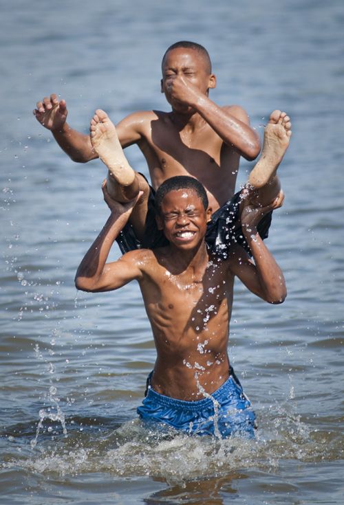 The image is of two boys playing in the lake. 